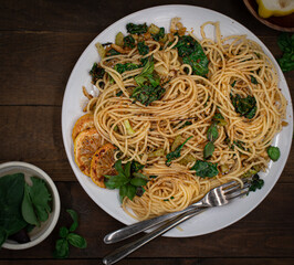 Vegan lemon and basil infused spaghetti dish on wooden table