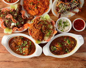 Assorted indian foods chicken biryani,chicken masala,chicken korma and chicken lollipop on wooden background. Dishes and appetizers of indian cuisine