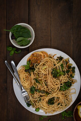 Vegan lemon and basil infused spaghetti dish on wooden table