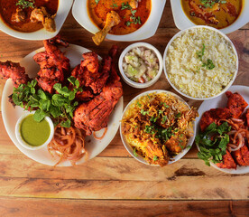 Assorted indian foods tandoori chicken,chicken biryani, chicken 65 and chicken masala on wooden background. Dishes and appetizers of indian cuisine