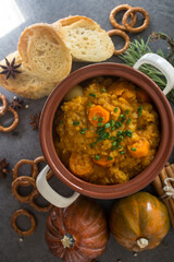 Pumpkin stew with lentils and chickpeas. Balanced vegetarian meal top view photo. Autumn receipts. Dark grey background with copy space.
