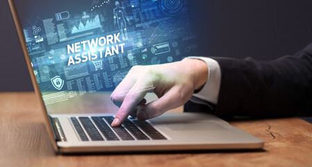 Obraz na płótnie Canvas Businessman working on laptop with NETWORK ASSISTANT inscription, cyber technology concept