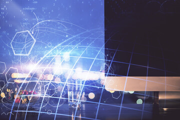 Double exposure of desktop with computer and world map hologram. International data network concept.