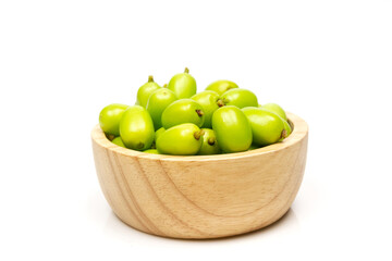 Fresh Neem fruit on wooden bowl isolated on white background. Neem fruit is an excellent moisturizing and contains various compounds that have insecticidal and medicinal properties.
