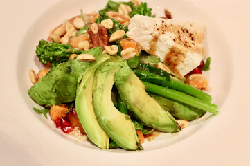 Healthy vegetarian salad meal with sliced avocado broccoli and feta cheese