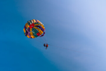 Parasailing in blue sky. Sports, active leisure, travel, vacation concept