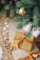 Stylishly wrapped gifts lying under decorated Christmas tree. Home decor for winter holidays.