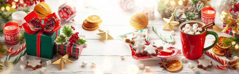 Winter composition with Christmas gift boxes, holiday sweets and Christmas decorations on wooden...