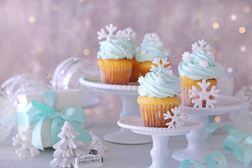 Christmas cupcakes with mint blue cream and white snowflakes.
Christmas decoration table over illumination.クリスマススノーフレークカップケーキ