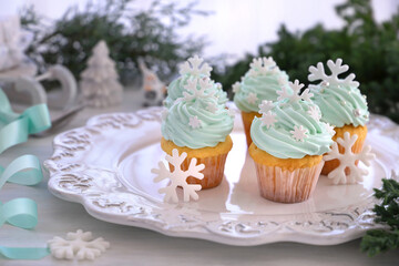 Christmas cupcakes with mint blue cream and white snowflakes on Christmas decoration table background. クリスクリスマススノーフレークカップケーキ