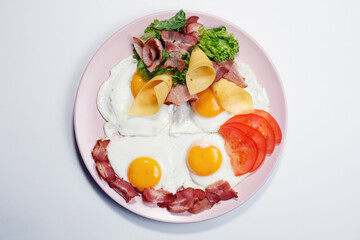 Fried eggs with bacon top view on a light background