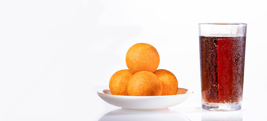 Cola fizzy drink with Colombian buñuelos - White background