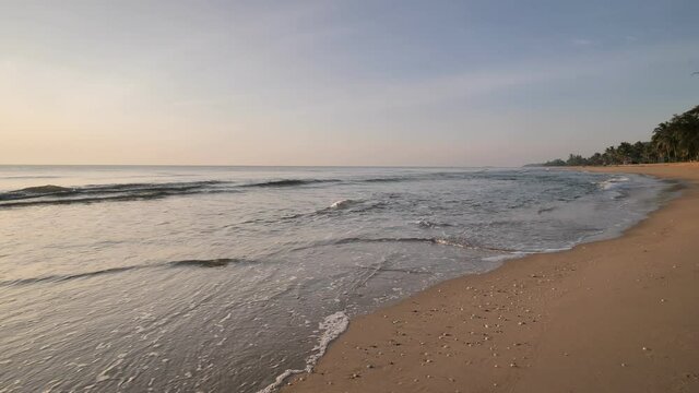 slow motion of seascape sunset on the beach with shell over the twilight sky and white wave bubbles a beautiful clear wave water lapping sand and shell on sea shore