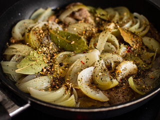 Pork steaks in frying pan with onion