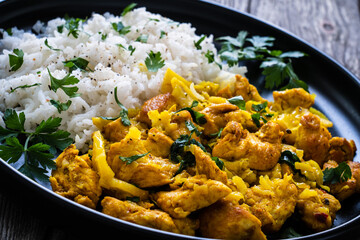 Chicken meat with rice and vegetables on wooden table
