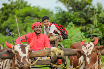 Indian farmer and his child on bullock cart