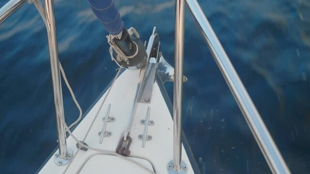 Up view of curtailed sail and jib furler on yacht sailing on river Volga. Water surface and sky are on backgorund.