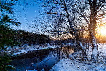 Landscape with winter forest and river. Sunrise, sunset in beautiful snowy forest.