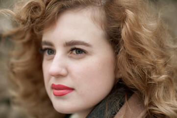 Portrait of a beautiful young woman near a stone wall. Close-up. Outside.