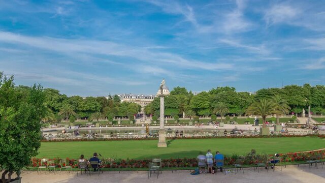The beautiful view of the Luxembourg Gardens timelapse hyperlapse with fountain in Paris, France. Blue cloudy sky at summer day.