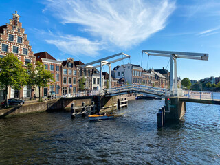 Haarlem, Netherlands - June 26. 2020: View over water canal in summer on double-beam drawbridge (Gravestenenbrug)