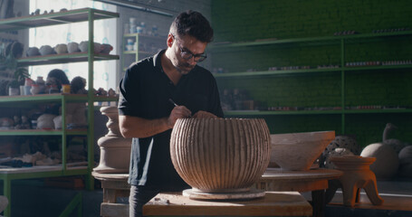 Potter creating ornament on clay bowl