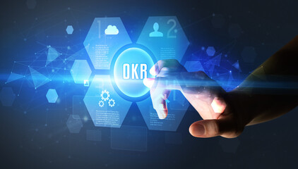 Hand touching OKR inscription, new technology concept