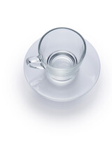 Empty glass cup with handle on glass saucer