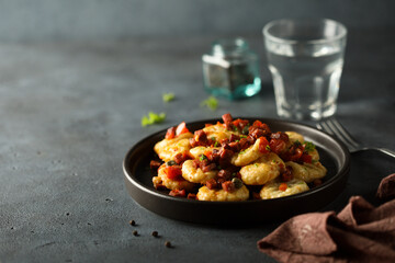Homemade gnocchi with fried sausage and tomato