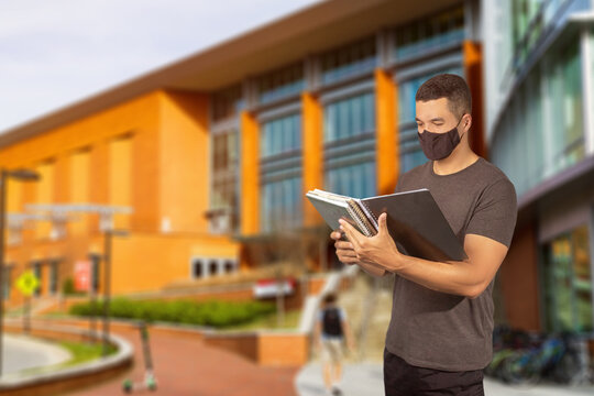 A Studant Man With Covid 19 Coronavirus Mask Holding A Copybook In Front Of School