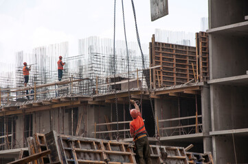 The builders make reinforcement strapping and attach the load to the tower crane hook. Construction of an apartment building in Krasnodar (Russia) on 30 October 2020.