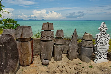 Naklejka premium Semporna. Malaysia. December 01, 2018. A rural cemetery on the island of Mabul. Due to the lack of large stones on the island, monuments are traditionally made from the trunks of palm trees, decorated