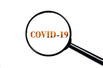 covid 19 and magnifying glass on white background.