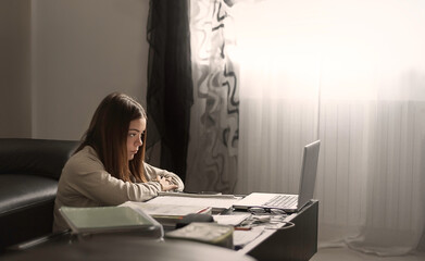 schoolgirl learning online from home, Covid 19;unwillingly with a notebook, distance learning, laziness, frustration and tiredness, pessimism - 389214760