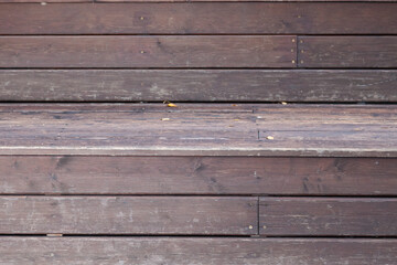 Fototapeta premium Close-up of a veranda wall made of brown and gray wooden planks with relief as a background for an autumn decor or billboard.
