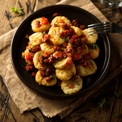 Homemade gnocchi with fried sausage and tomato