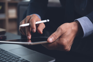 Close up of business man hand using digital tablet working in office