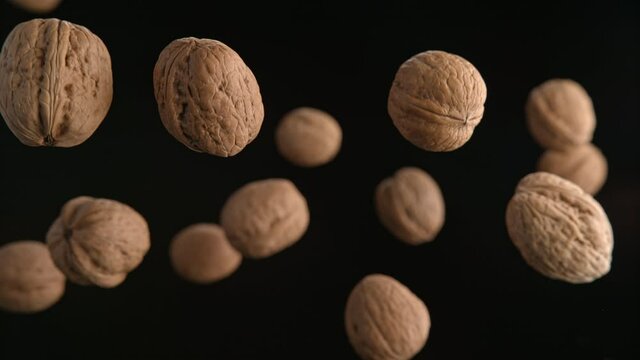 Walnuts in Shells Flying on the Black Background. Shot in 1000fps with Phantom Flex 4K