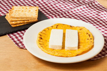 Tasty traditional breakfast in Colombia; Arepa of yellow corn with cheese.