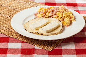 Arepa for breakfast, cheese and scrambled egg, a traditional Colombian dish.