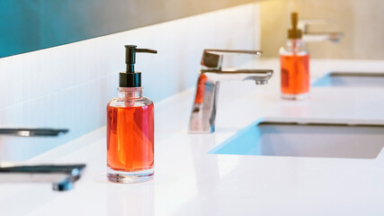 Orange sanitary liquid soap or antivirus soap sanitizer for hand washing to prevent the spread of...