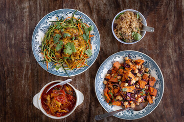 
full table healthy Indian, Asian and Mediterranean dishes with white beans, lentils, sweet potatoes, rice and vegetables