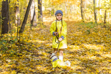 Child girl with dog outdoors. Kid with pet at autumn. Jack russell terrier puppy.