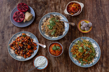 
full table healthy Indian, Asian and Mediterranean dishes with white beans, lentils, sweet potatoes, rice and vegetables