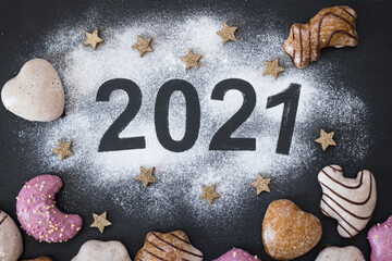 Christmas and New Year 2021 theme: golden stars and gingerbread cookies on the dark background