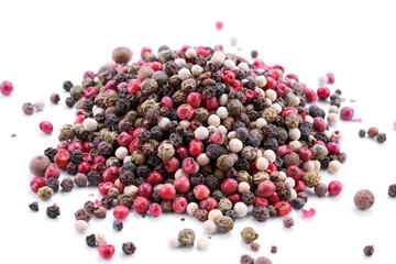 Heap of black, red and white peppercorns on white table isolated with copy space, top view. Food background