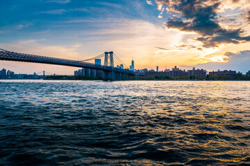 Cloudy evening sunset by the Manhattan bridge with a view of New York City skyline