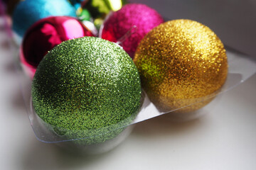 shiny round Christmas toys on the Christmas tree in transparent plastic packaging side view . before Christmas