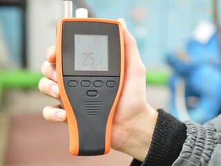 Checking the air condition with the device. Measurement of air temperature and humidity. Part of the image is blurred.