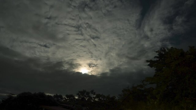 Cloudscape timelapse footage. Cloudy nighttime in full moon night beautiful moonlight shine through dark clouds sky. Nature background.